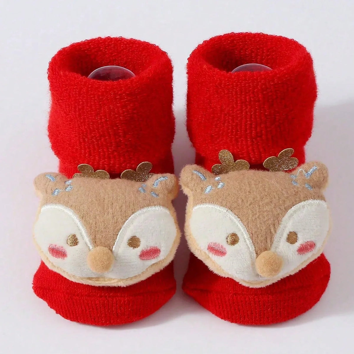 Red cuffed baby socks with tan-and-cream fawn faces, pink cheeks, and small antlers.