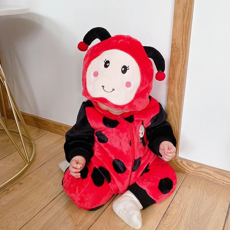 Child wearing red ladybug plush hooded romper costume sitting on floor