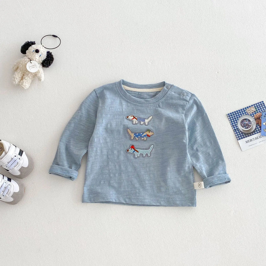Blue long-sleeve cotton top with three dog appliqués