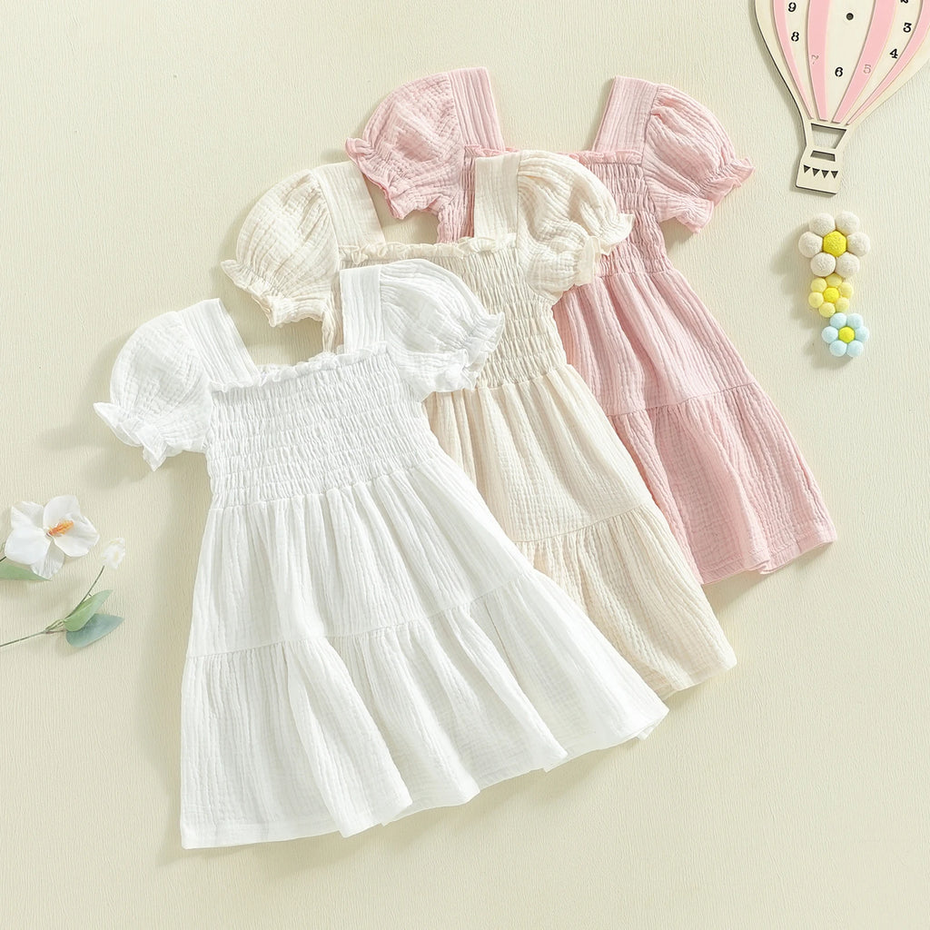 Smocked puff-sleeve dresses in white, ivory, and pink