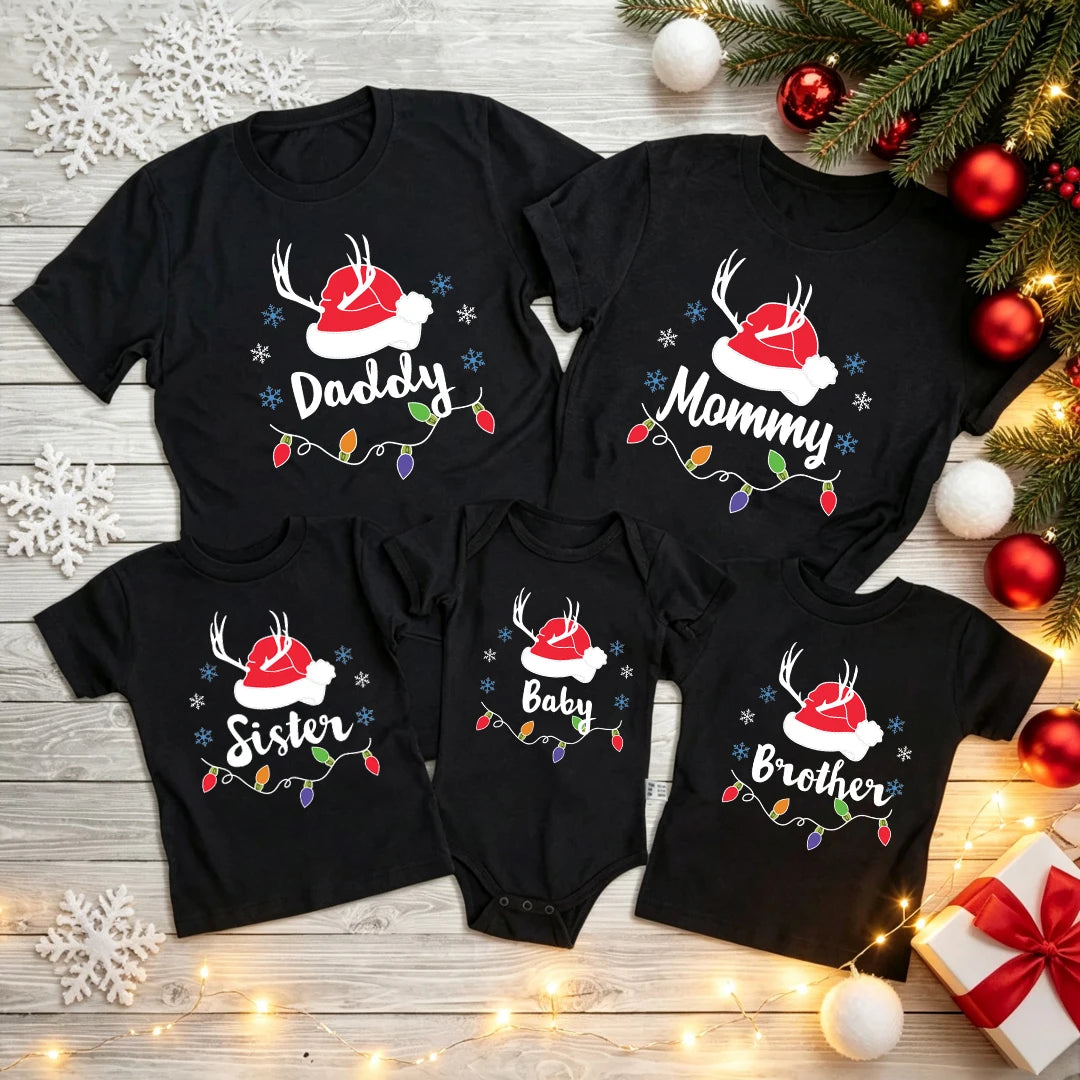 Black Christmas T-shirts and a baby bodysuit with Daddy, Mommy, Sister, Brother, and Baby lettering, Santa hats, antlers, and colorful lights.