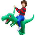Child wearing green inflatable dinosaur costume with blue pants, holding handles on dinosaur's neck
