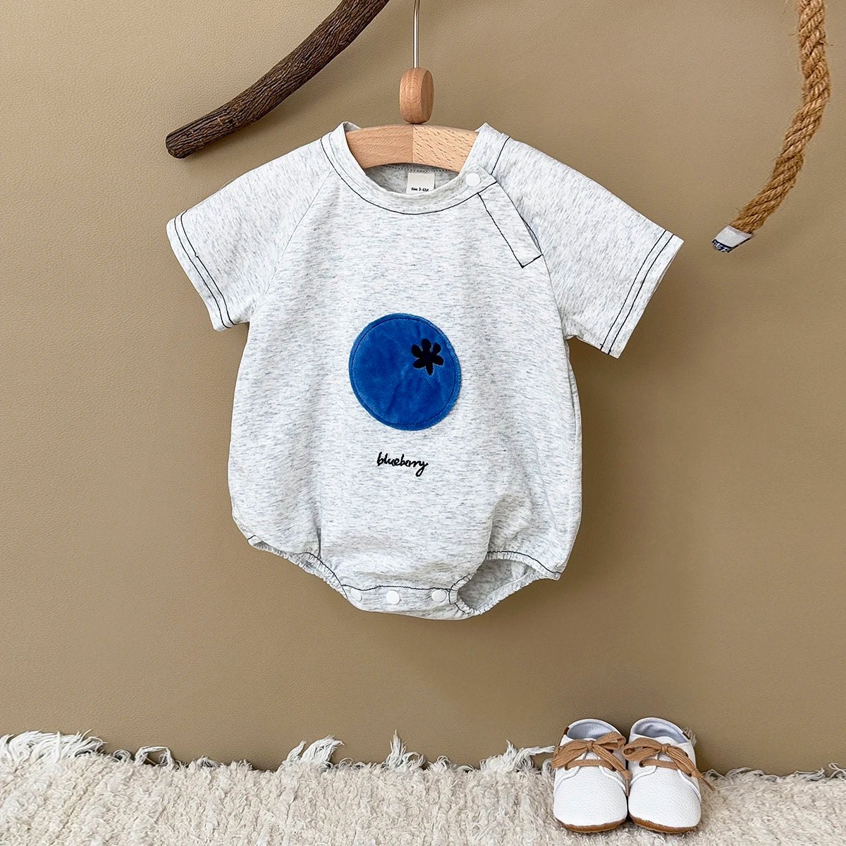 Gray Fruit Patch Bubble Romper displayed on hanger