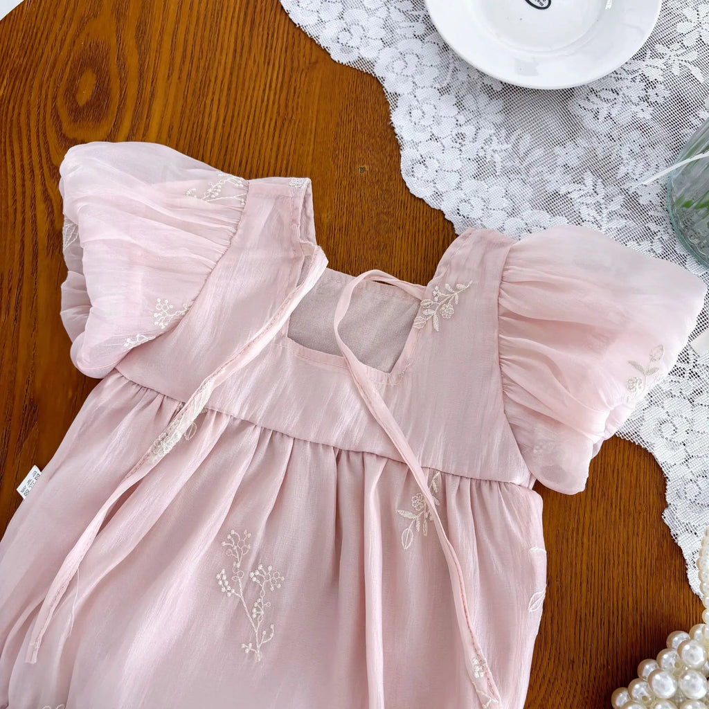 Back view of pink baby romper with embroidered details