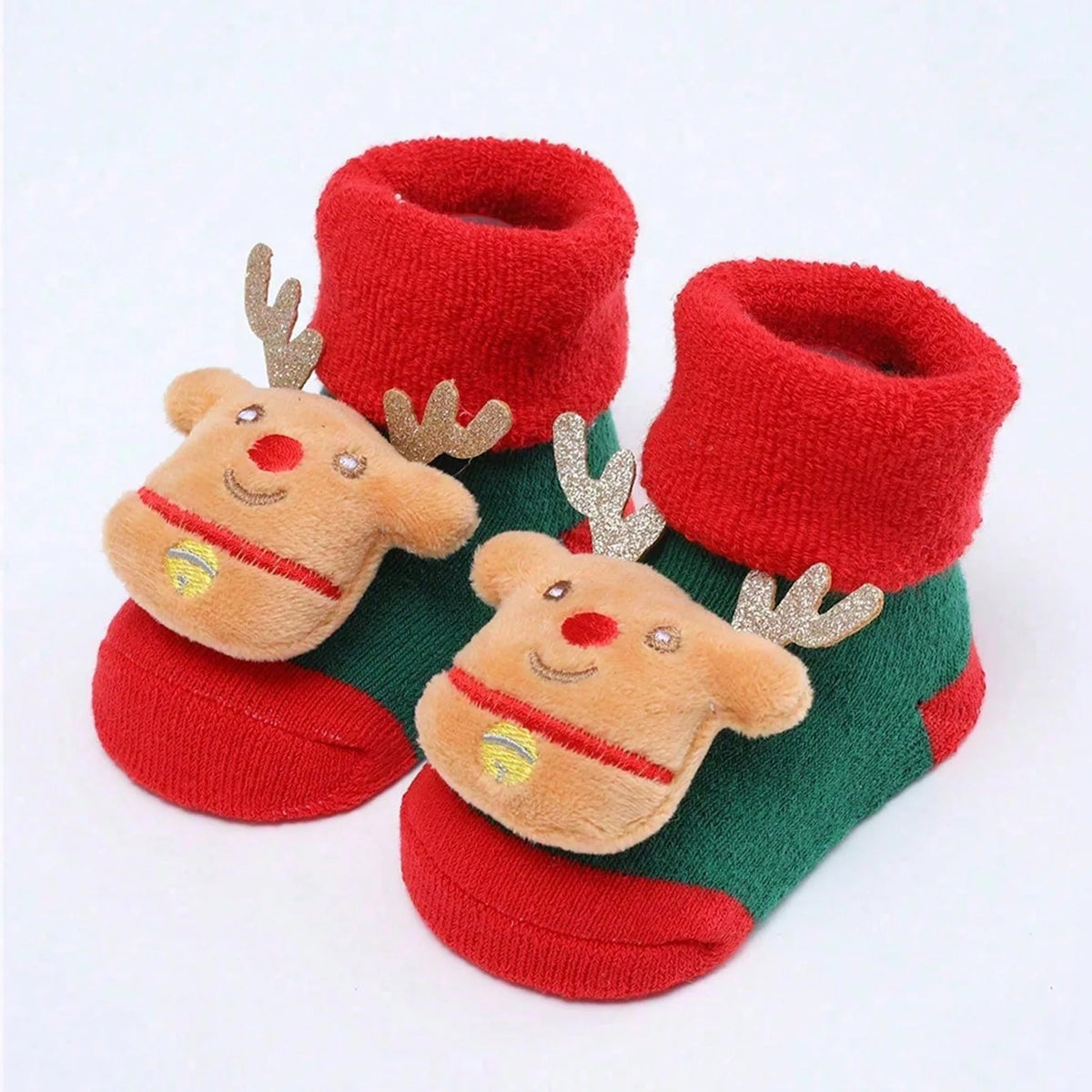 Green baby socks with red cuffs and toes, reindeer face appliques, glittery antlers, and gold-colored bell details.