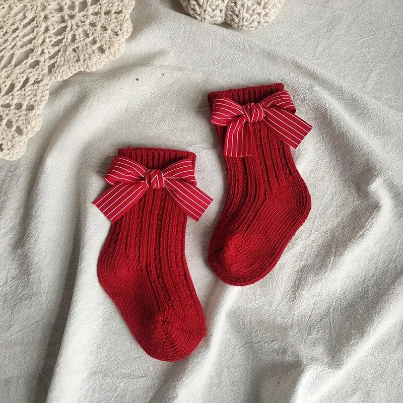 Red ribbed knee-high socks with striped bows