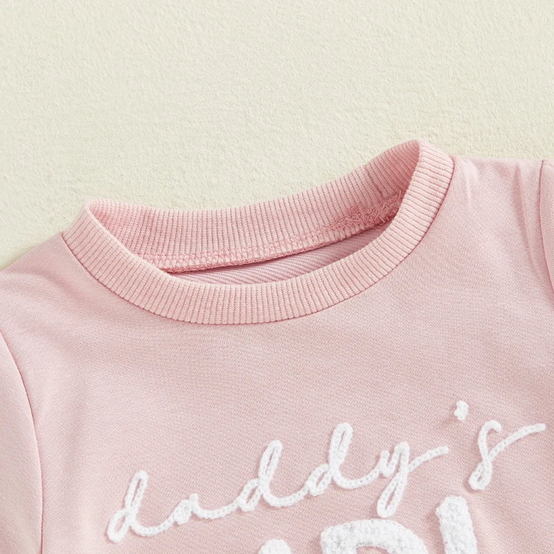 Close-up of floral embroidery on baby romper