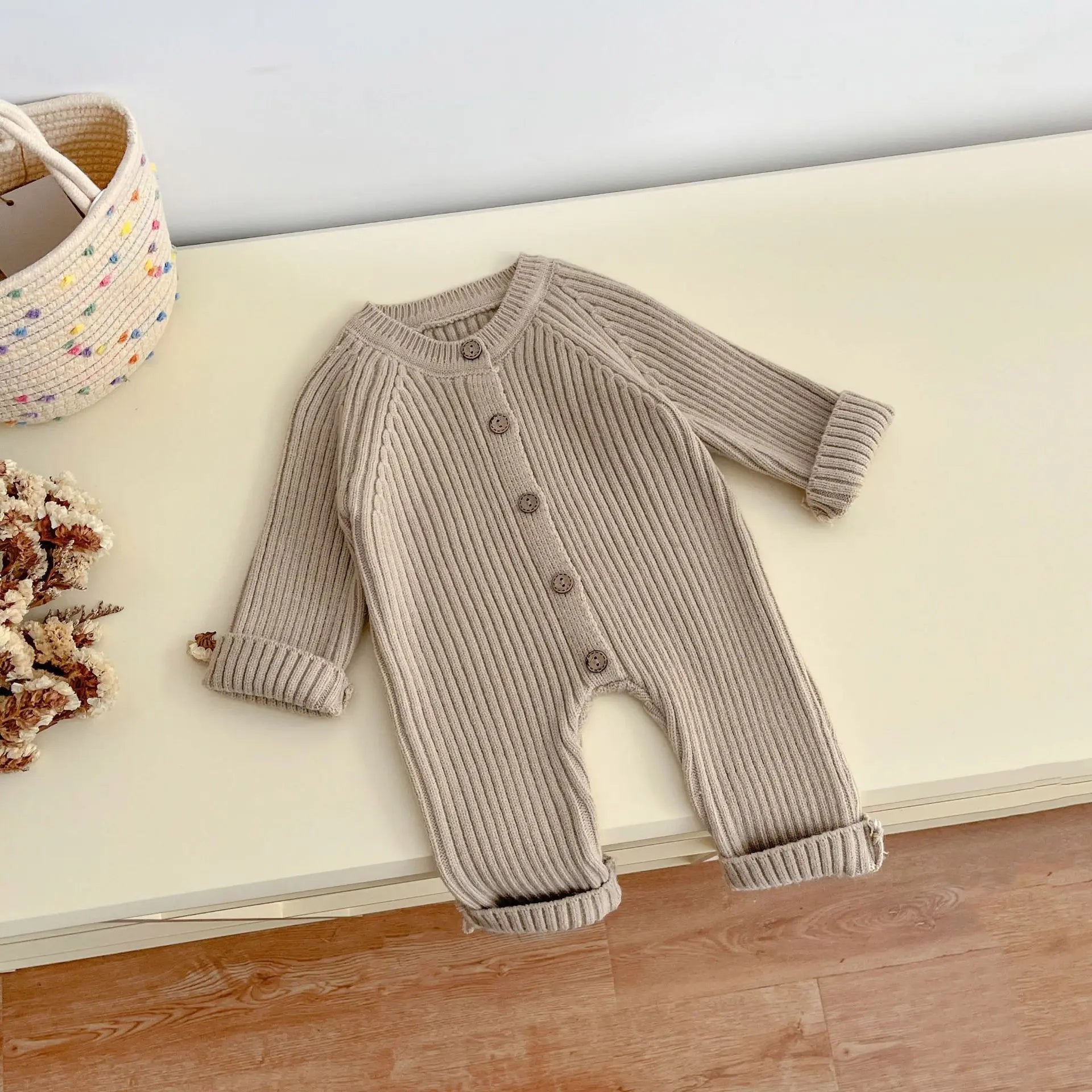 Knitted baby bodysuit displayed flat