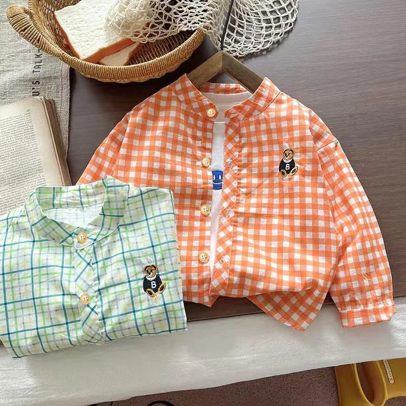 Orange and blue plaid children’s button-up shirts with embroidered bear patches