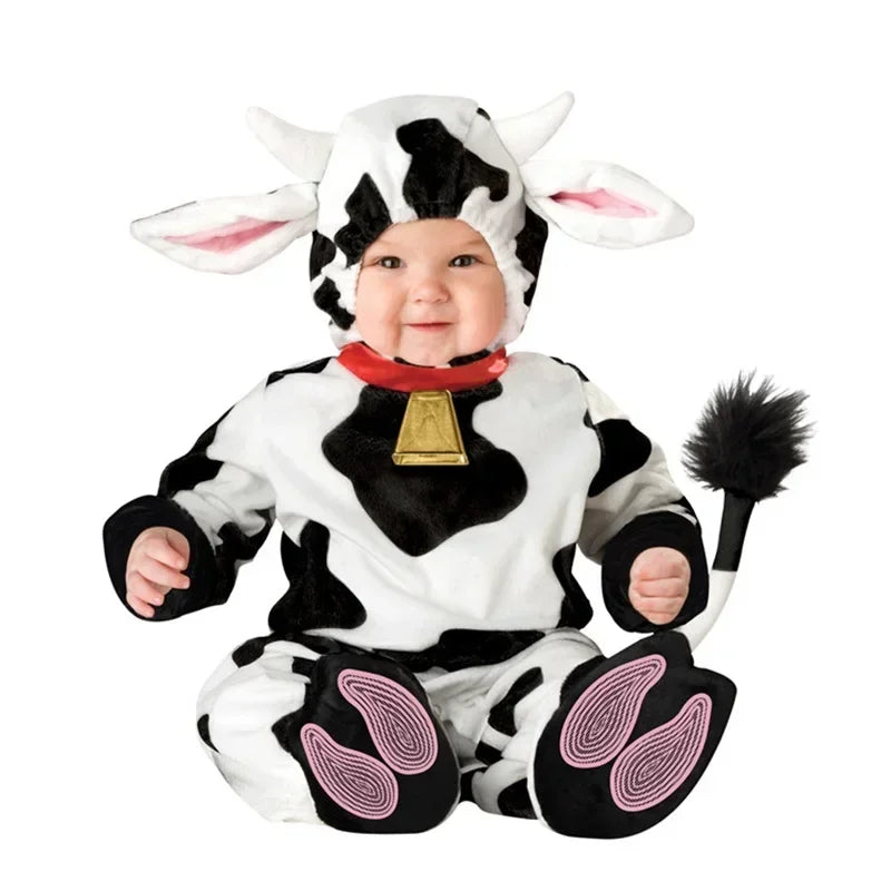 Toddler wearing a cow jumpsuit costume with hood, ears, horns, red collar with bell, and hoof print booties.