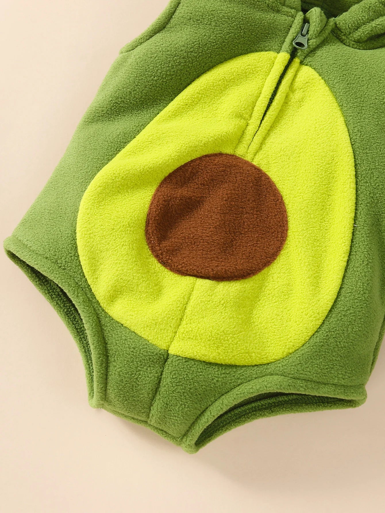 Close-up of brown seed applique on front of avocado romper costume