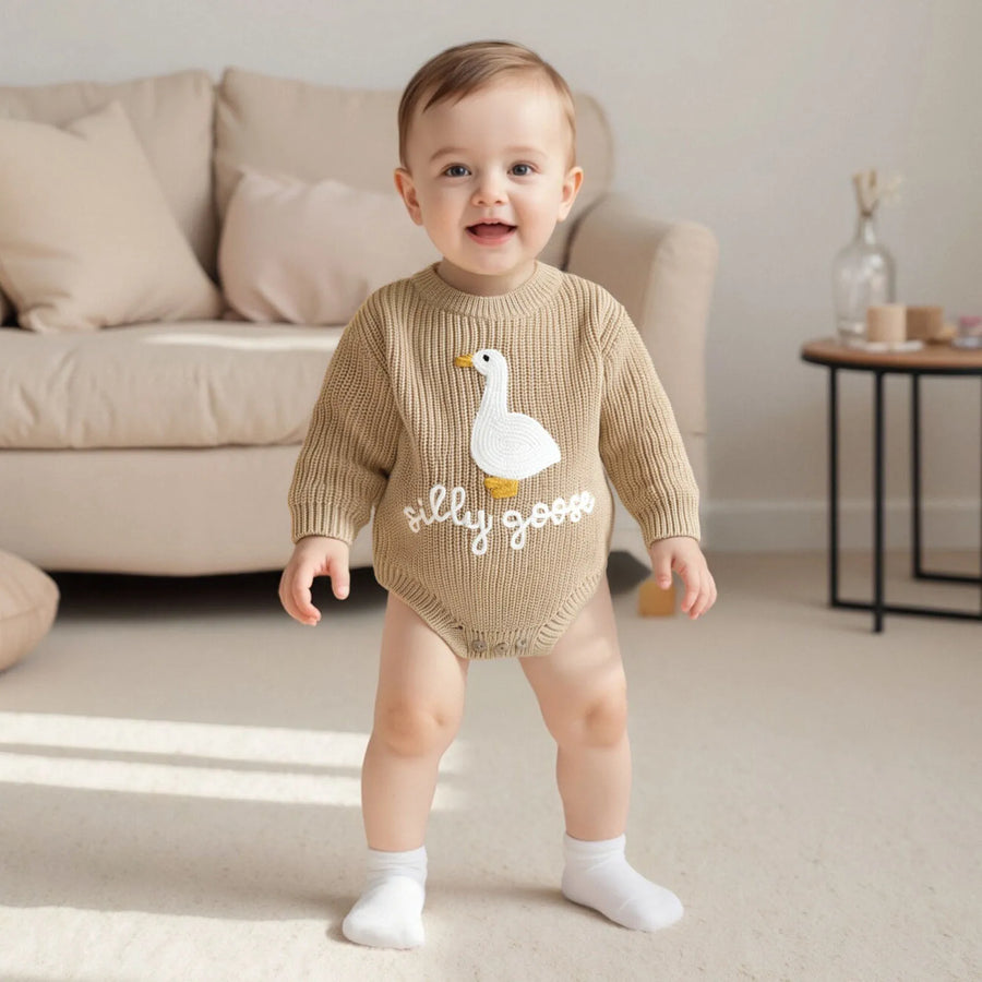 Close-up of white goose letter embroidery on knitted baby romper