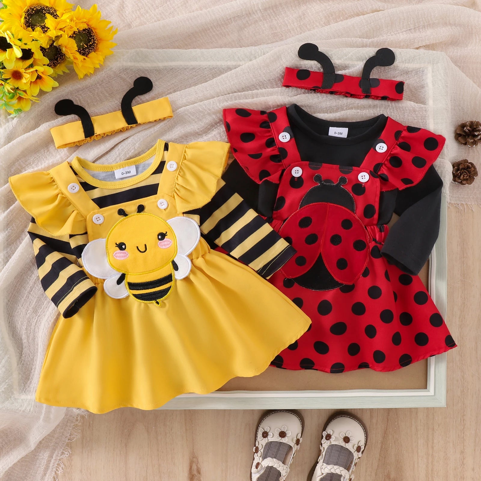 Both baby girls insect costume sets side by side showing differences in romper and dress design