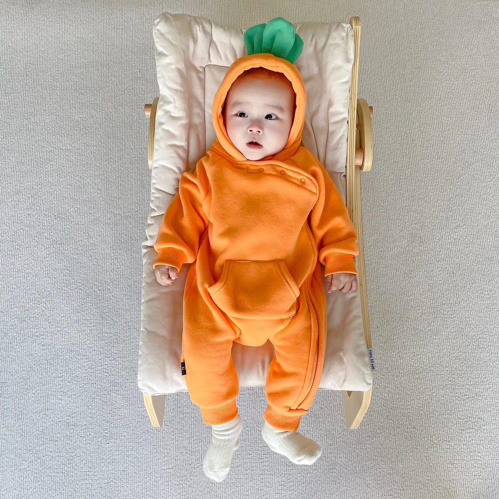 Baby in carrot costume jumpsuit lying on baby chair back view