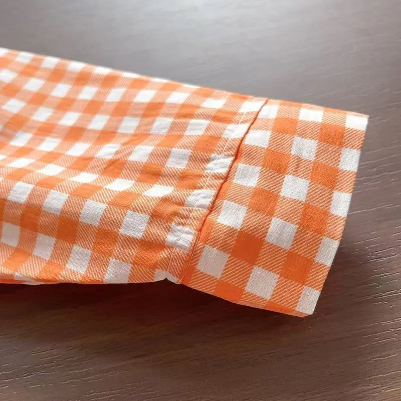 Long-sleeve cuff detail on orange plaid shirt