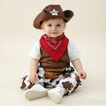 Baby boy wearing cowboy costume romper set with cow-print pants, brown vest, red bandana, and cowboy hat