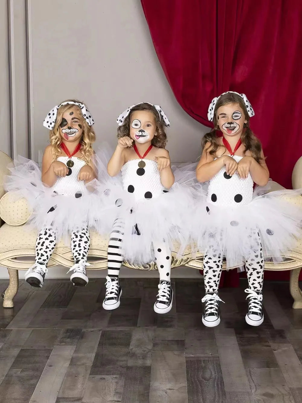 Three children wearing Dalmatian dog tutu dress costumes with face paint and dog ear headbands