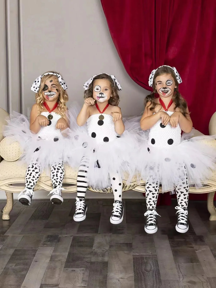 Three children wearing Dalmatian dog tutu dress costumes with face paint and dog ear headbands