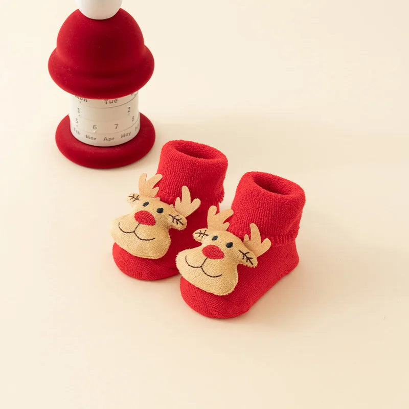 Red baby socks with folded cuffs and tan reindeer faces with red noses.