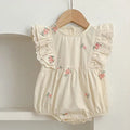 Flat lay of baby girl cotton bodysuit with floral embroidery