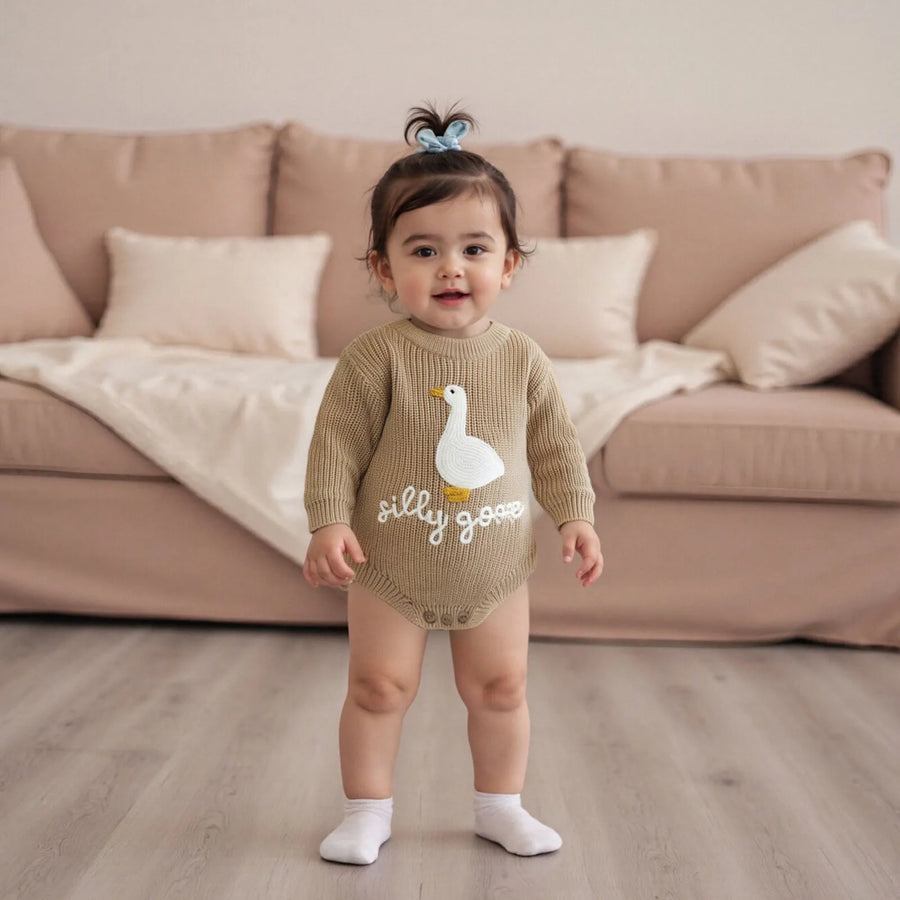 Baby wearing knitted romper with long sleeves and goose embroidery
