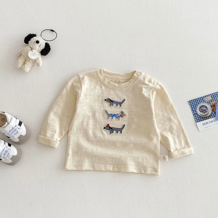 Beige long-sleeve cotton top with three dog appliqués