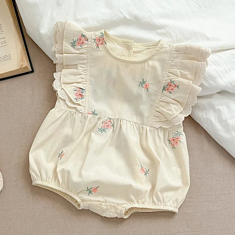 Close-up of floral embroidery on baby girl bodysuit