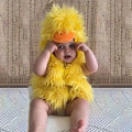 Infant wearing a yellow duck-themed fluffy romper costume with hood featuring duck bill and eyes
