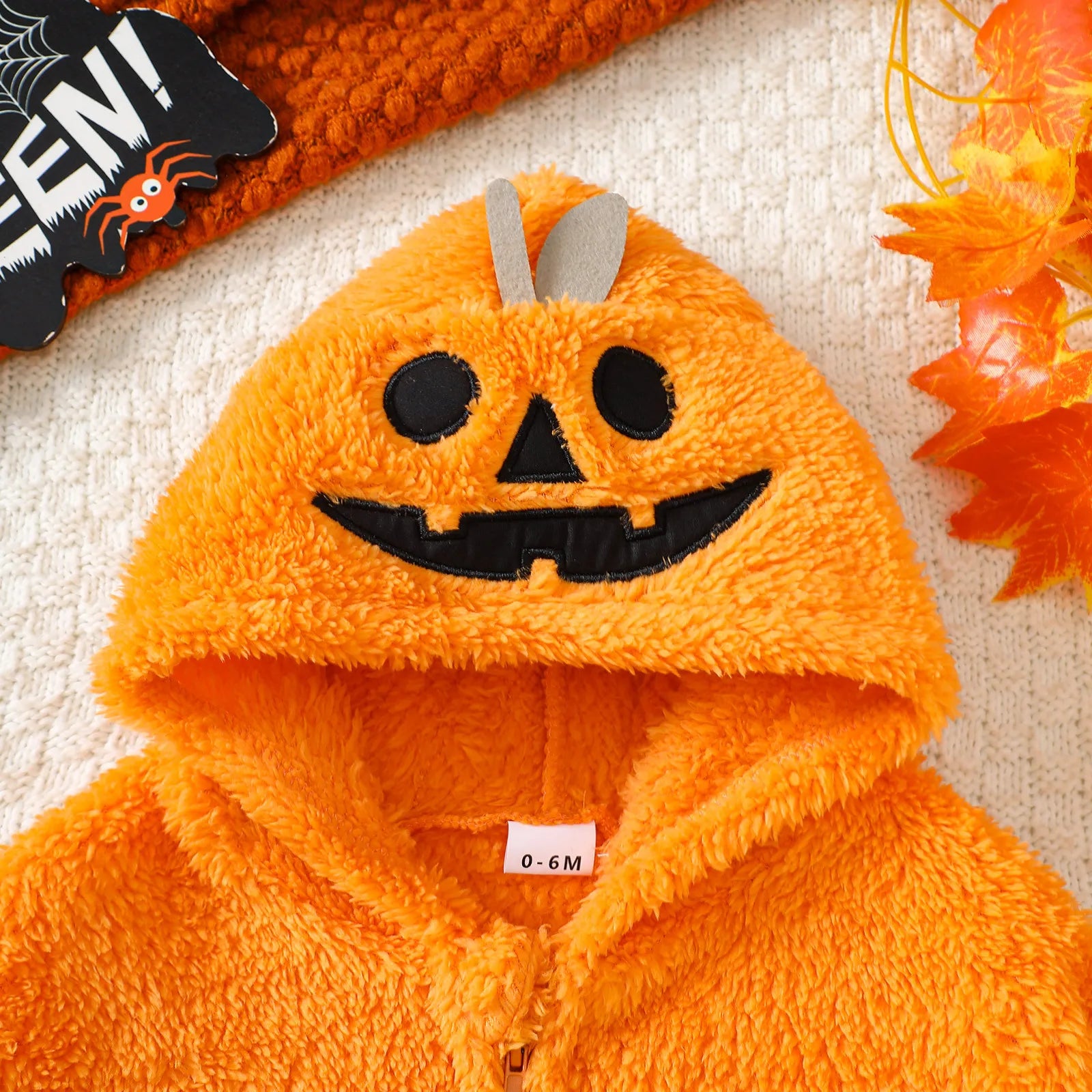 Close-up of pumpkin face hood on orange fleece cloak costume