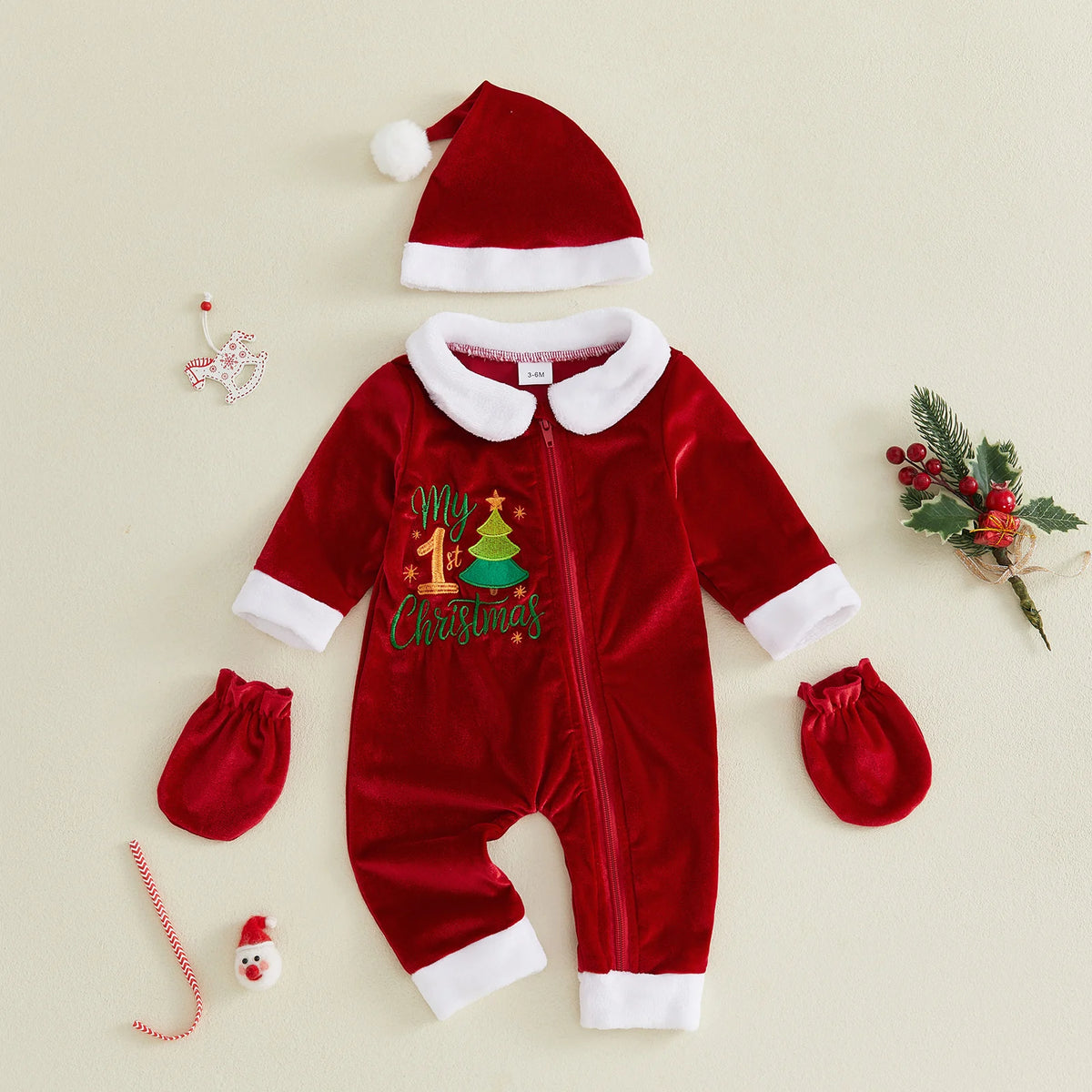 Red zip-front My 1st Christmas baby romper with a white collar and cuffs, shown with a Santa hat and matching mittens.