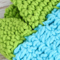Close-up of crochet yarn texture in green and blue colors