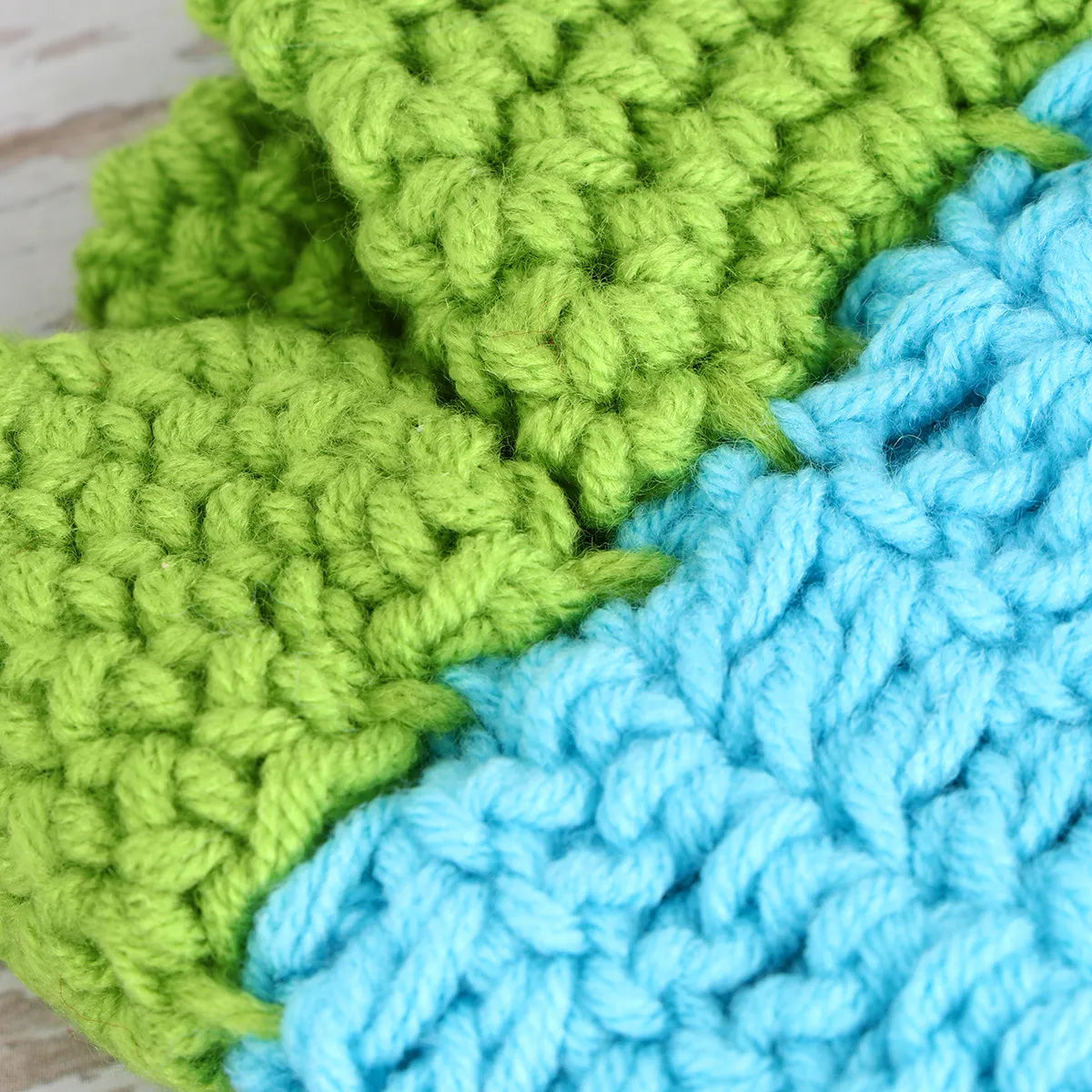 Close-up of crochet yarn texture in green and blue colors