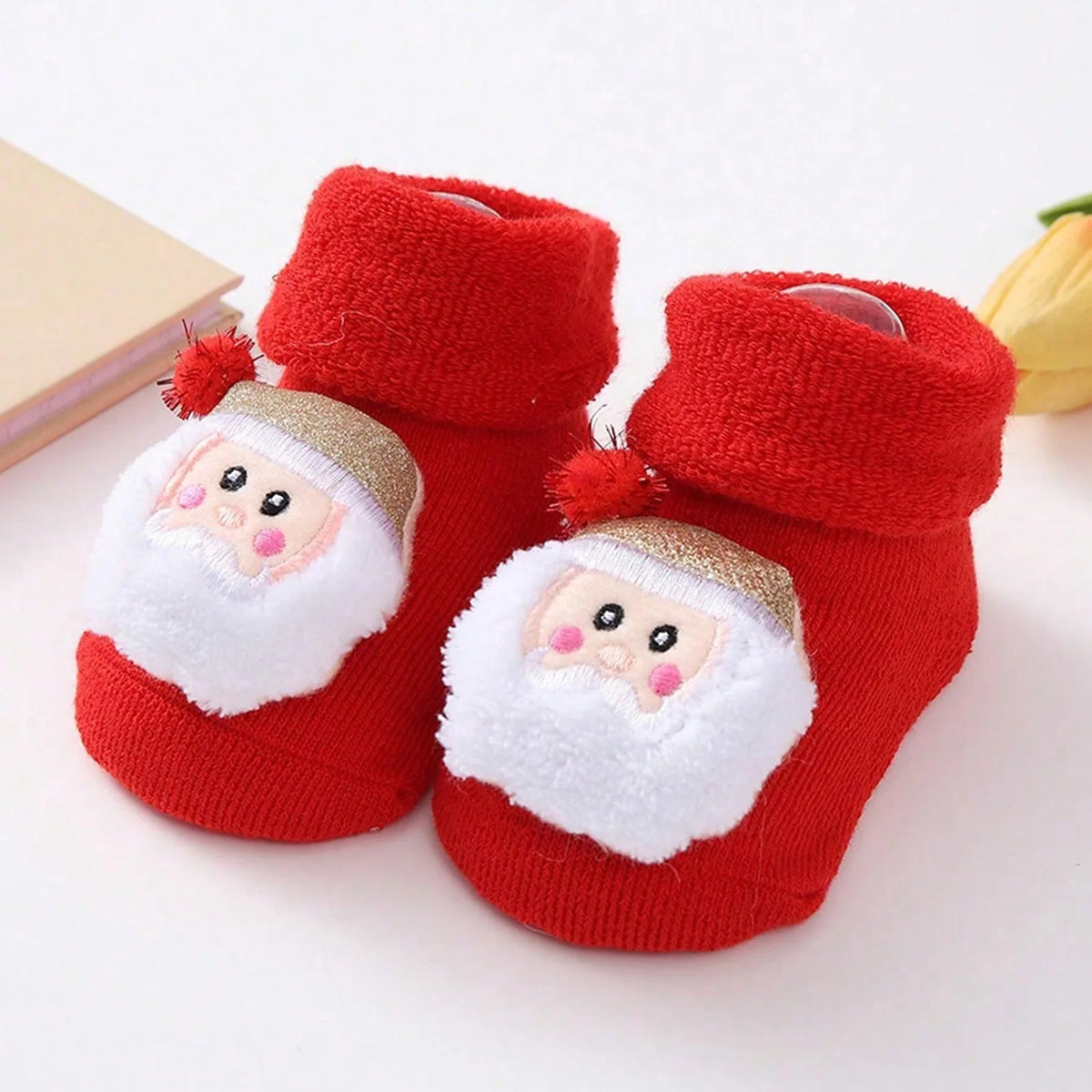 Red cuffed baby socks with white-bearded Santa faces and gold-colored hats with red pom-poms.