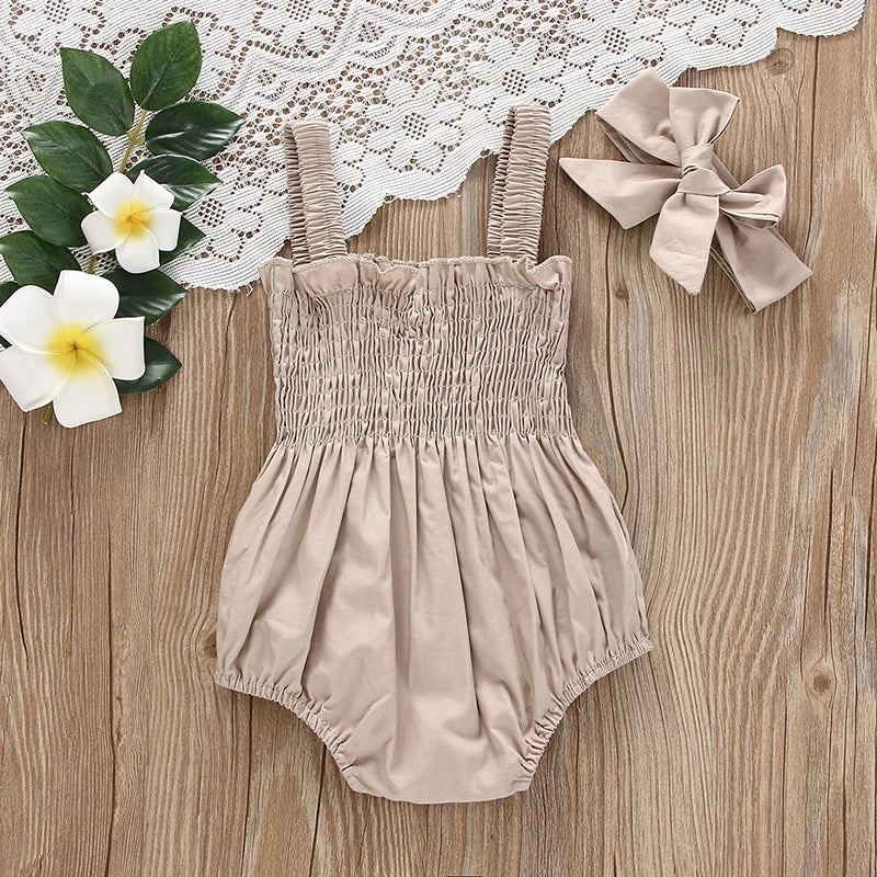Baby girl wearing ruched sleeveless romper with headband