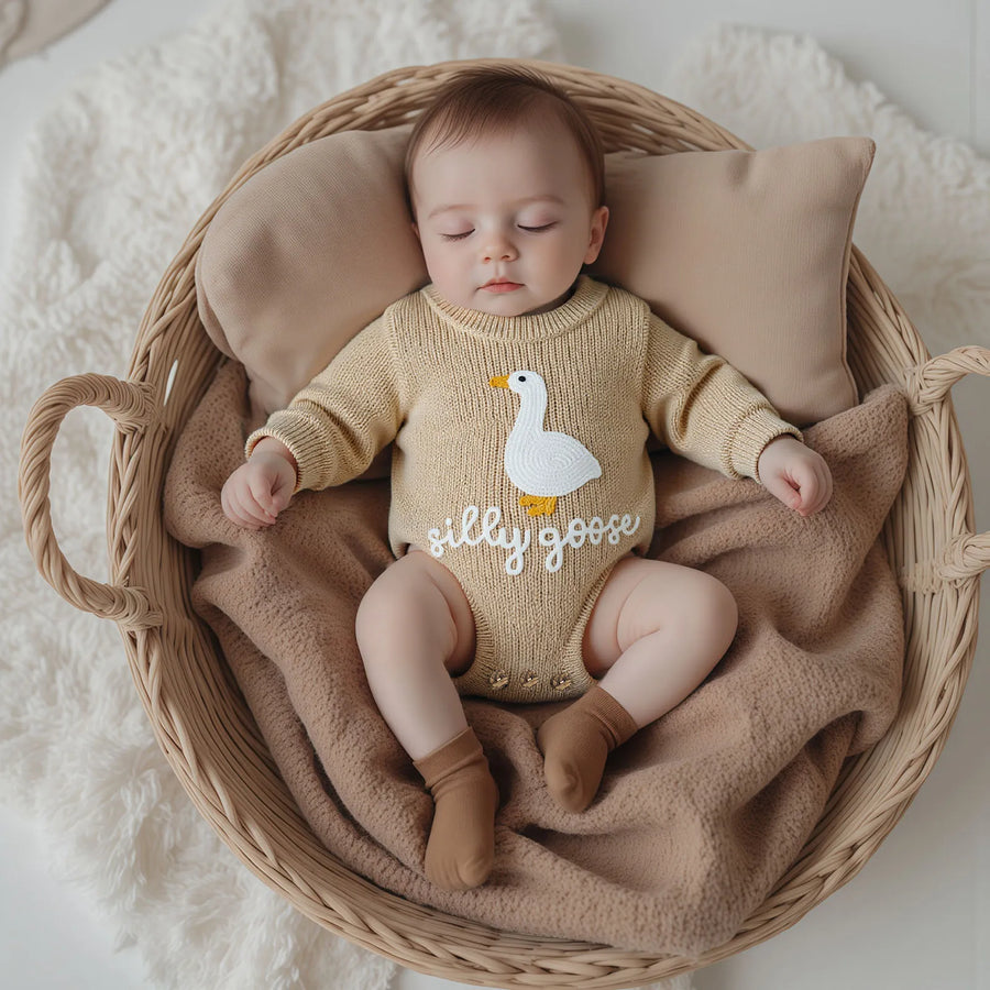 Knitted baby romper in ivory color with embroidered goose detail