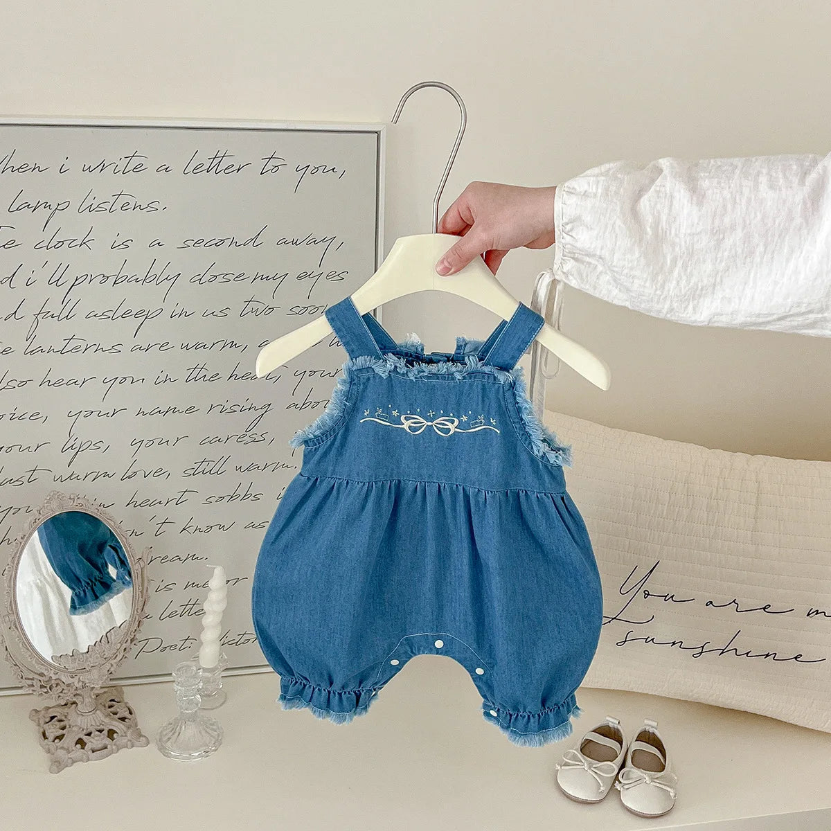 Side view of cotton denim overall romper with bow embroidery for girls