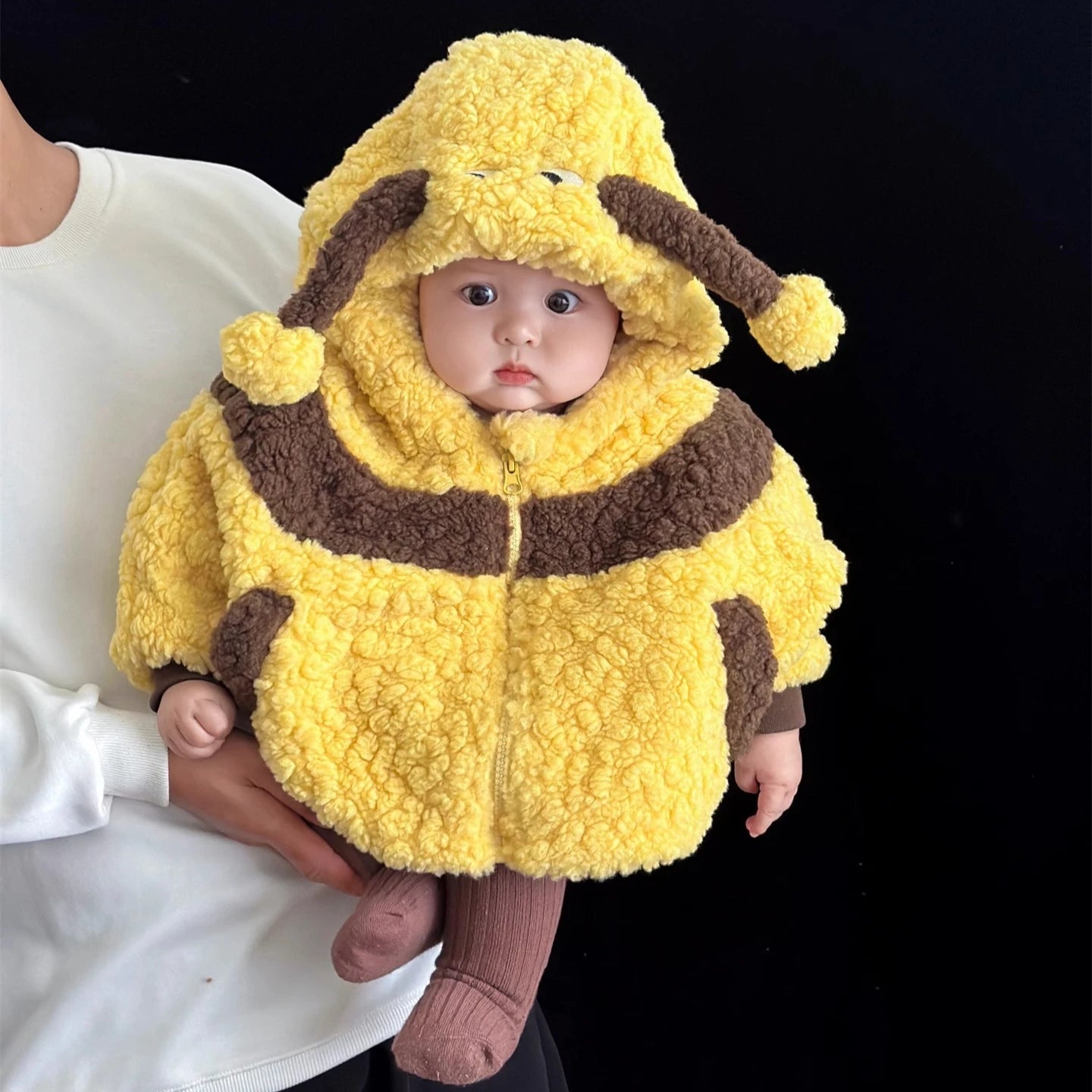 Infant wearing a yellow and brown bee hooded cape costume with antennae pom-poms