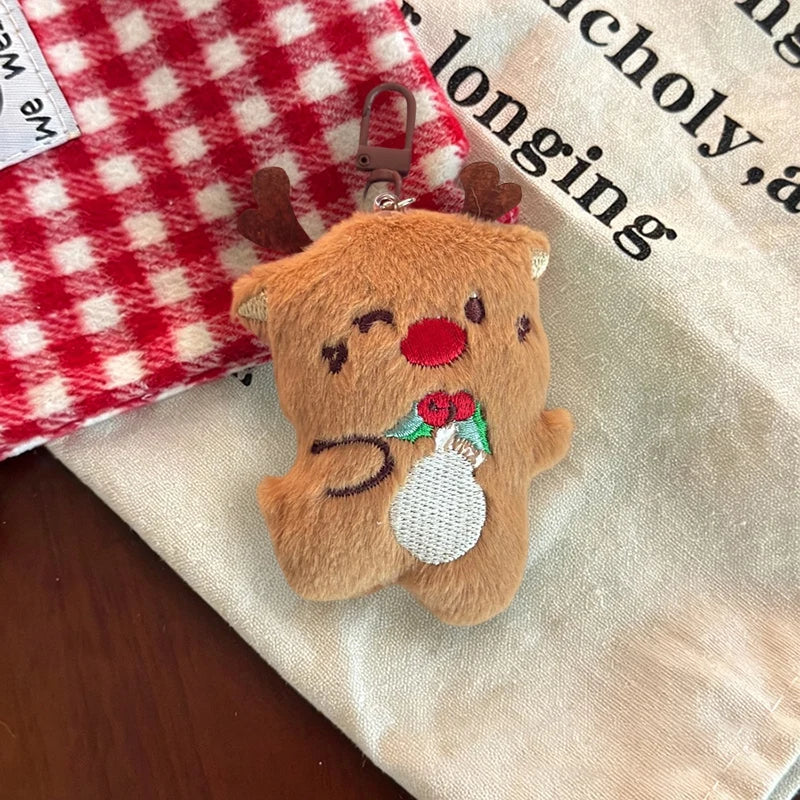 Brown reindeer plush Christmas ornament with antlers, a red nose, stitched holly, and a brown clip.