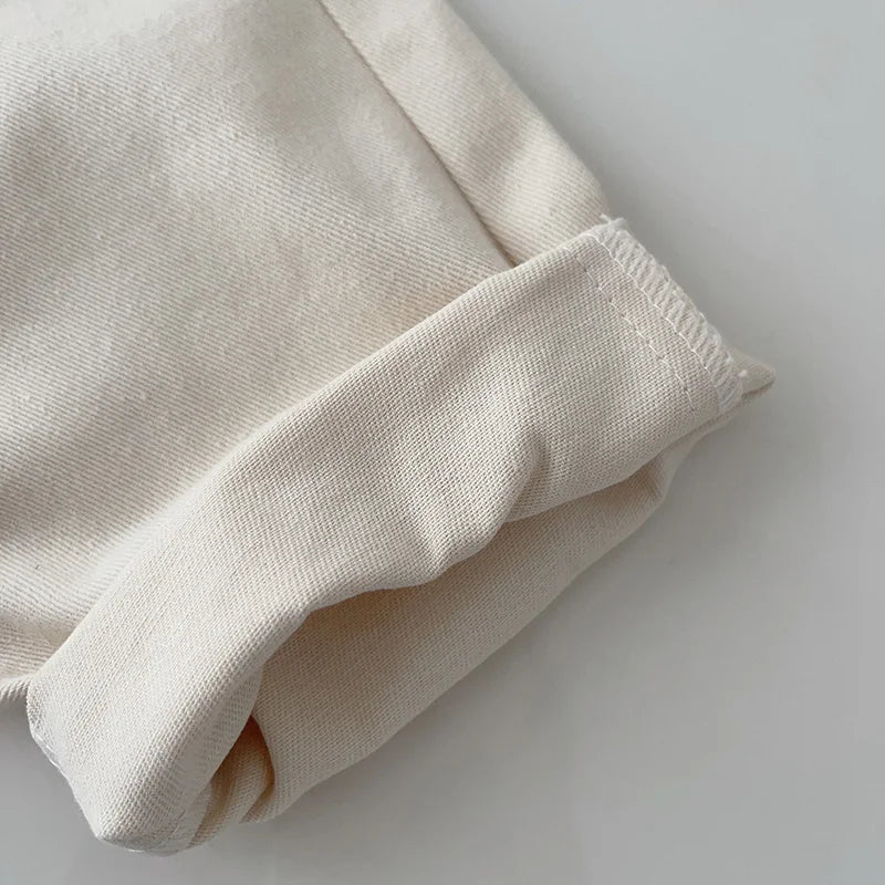 Turned cuff and hem stitching detail on beige denim pants