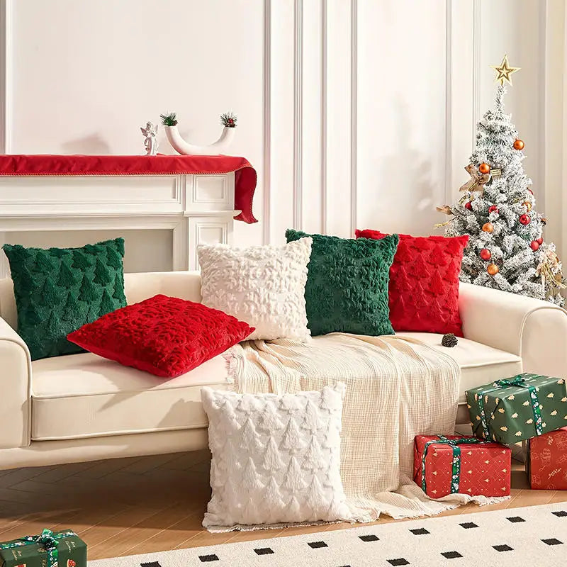Red, green, and white textured cushions with raised Christmas tree and tufted patterns, arranged on a cream sofa.