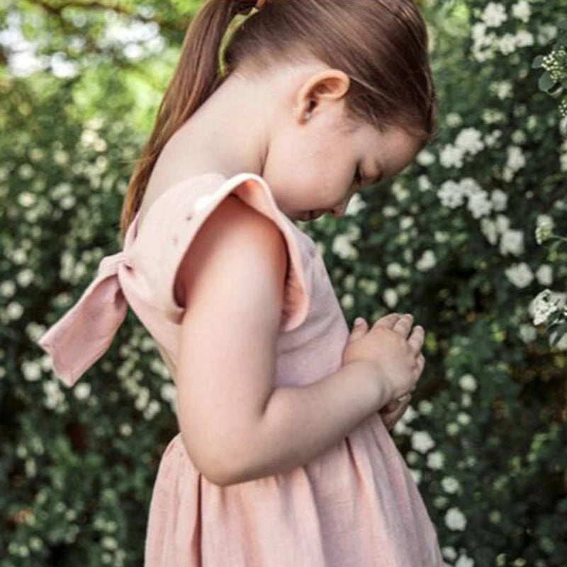 Blush pink sleeveless ruffle-back dress on a child