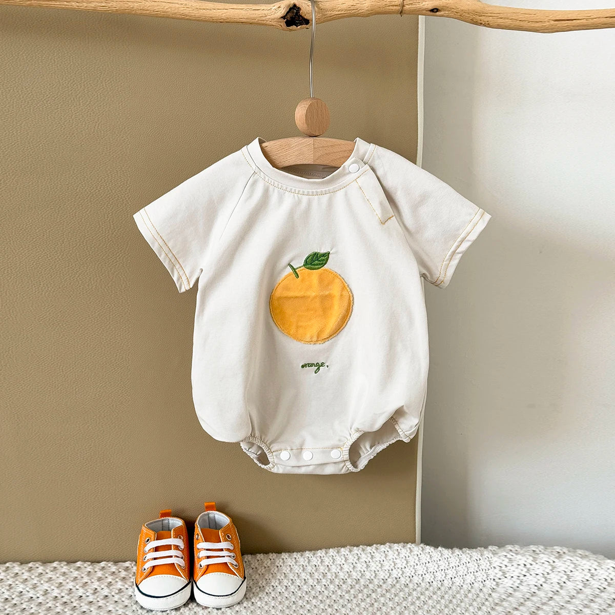 Apricot Fruit Patch Bubble Romper displayed on hanger