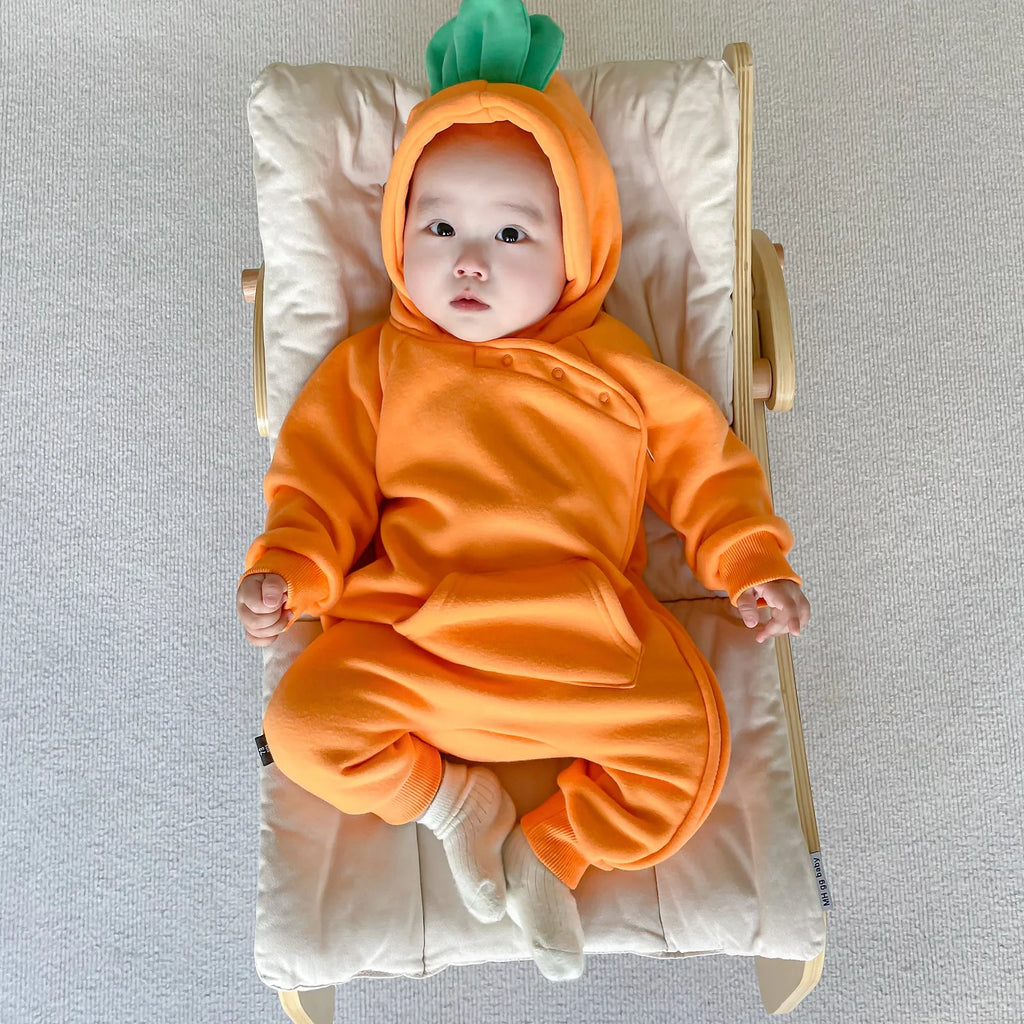 Baby in carrot costume jumpsuit lying on baby chair
