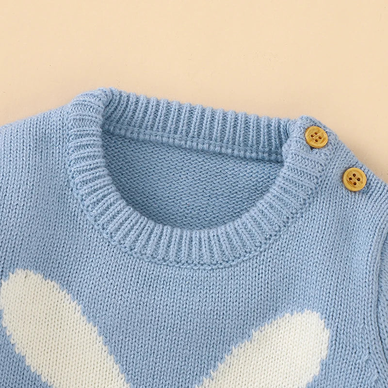 Close-up of knitted rabbit pattern on baby romper