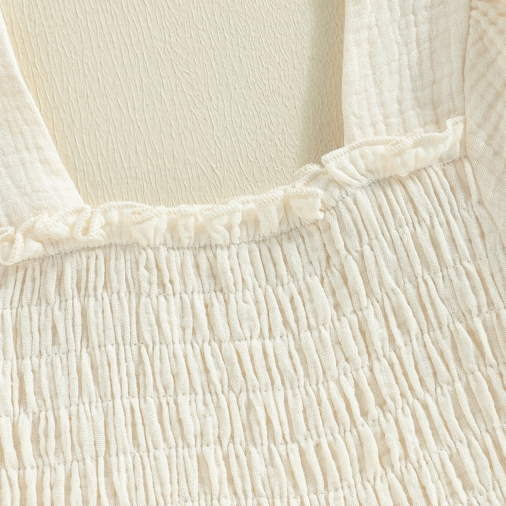 Square neckline and smocked bodice detail on ivory dress