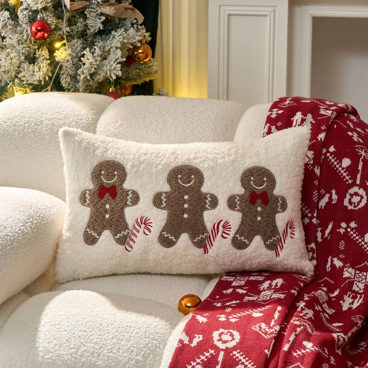 Christmas pillow cover featuring three gingerbread figures with candy-cane details.