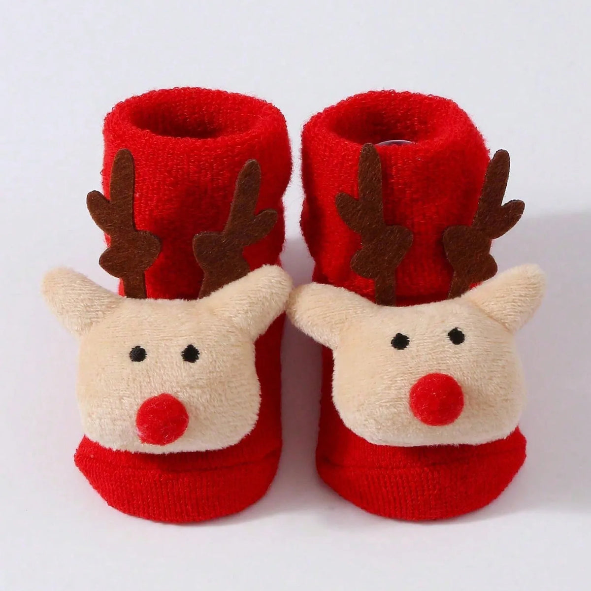 Red cuffed baby socks with cream reindeer faces, round red noses, and tall brown antlers.