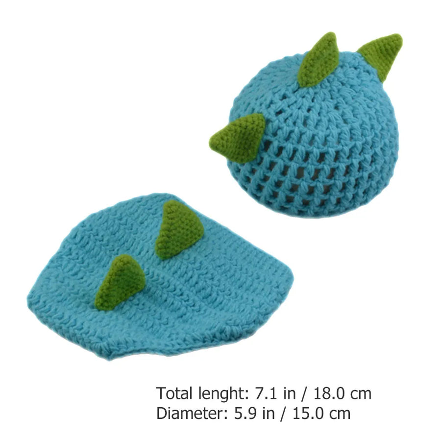 Knitted blue dinosaur hat and diaper cover with green spikes, shown with size measurements
