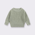 Green knitted sweater on a light gray background