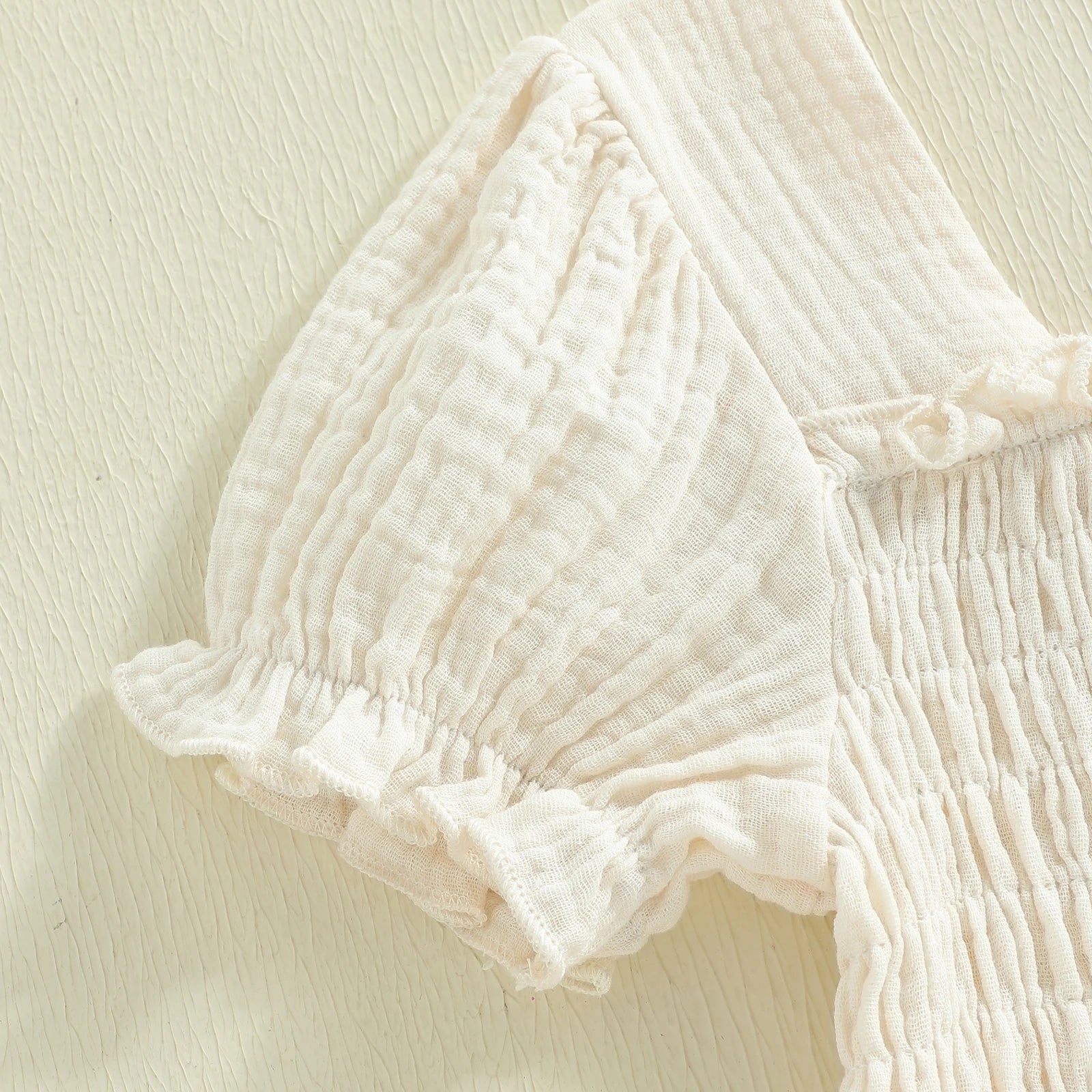Short puff-sleeve detail on ivory smocked dress